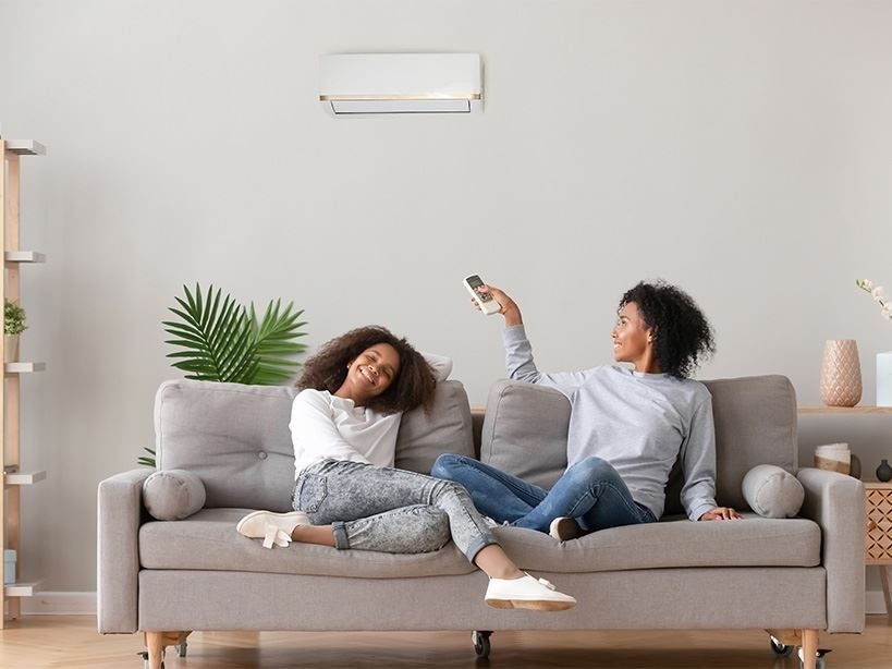 Two women on couch under AC